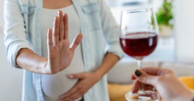 pregnant woman refusing a glass of wine. alcohol in pregnancy. unrecognizable expectant lady gestring stop to offered glass of wine