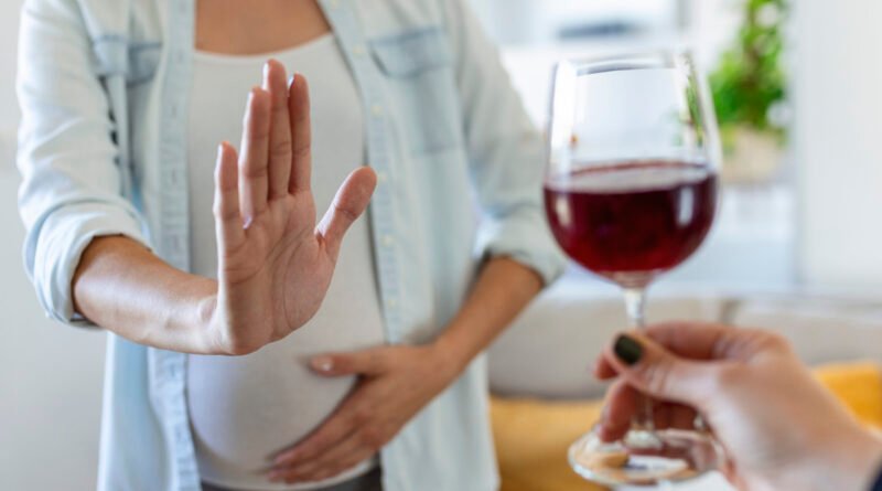 pregnant woman refusing a glass of wine. alcohol in pregnancy. unrecognizable expectant lady gestring stop to offered glass of wine